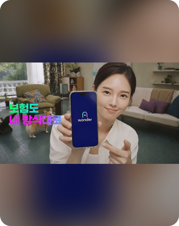 wonderer 앱이 켜진 스마트폰을 들고 미소 짓는 여성